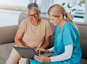 Older adult and family member reviewing an assisted living contract with a fee schedule at a table.